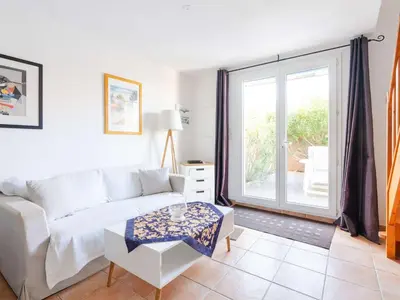 a living room with a couch and a table at Pavillon climatisé 4 pièces avec WIFI, proche plage, terrasse, barbecue, park. privatif, animaux admis - FR-1-409-249 in Gruissan