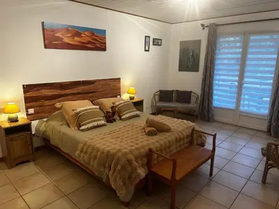 a bedroom with a bed and two lamps and a window at Oasis Des Corbières in Boutenac