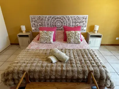 a bedroom with a large bed with a blanket and pillows at Oasis Des Corbières in Boutenac