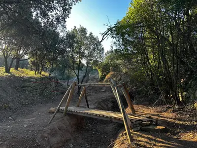 a wooden bench sitting on top of a dirt field at Oasis Des Corbières in Boutenac