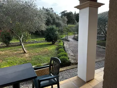 a patio with a table and chairs and a view of a park at Oasis Des Corbières in Boutenac