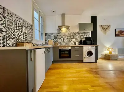 a kitchen with a counter and a washer and dryer at Le Petit Balcon de Verdun - Carcassonne centre in Carcassonne