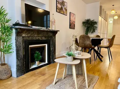 a living room with a table and a fireplace at Le Petit Balcon de Verdun - Carcassonne centre in Carcassonne