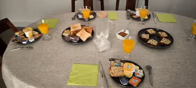 a table with plates of food and glasses of orange juice at Suite Napoléon - La Halte d'Eugénie in Félines-Termenès