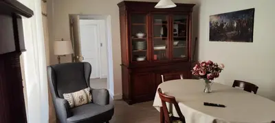 a living room with a table and a chair and a cabinet at Suite Napoléon - La Halte d'Eugénie in Félines-Termenès