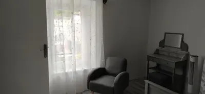 a living room with a chair and a window at Suite Napoléon - La Halte d'Eugénie in Félines-Termenès