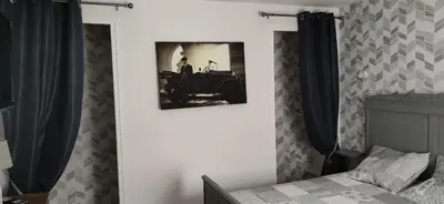 a bedroom with a picture of a car on the wall at Suite Napoléon - La Halte d'Eugénie in Félines-Termenès