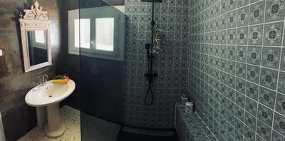 a blue tiled bathroom with a sink and a shower at La Babayaga in Capestang