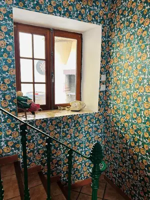 a room with a window and colorful wallpaper at La Babayaga in Capestang