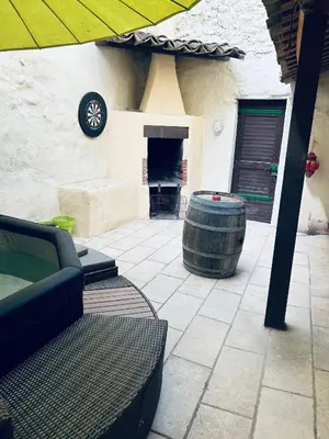 a patio with a barrel sitting next to a building at La Babayaga in Capestang