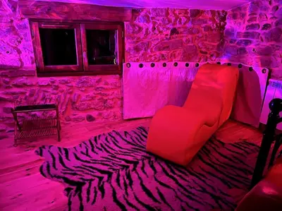 a room with a red couch and a zebra carpet at Love room de Blanche Neige in Assignan