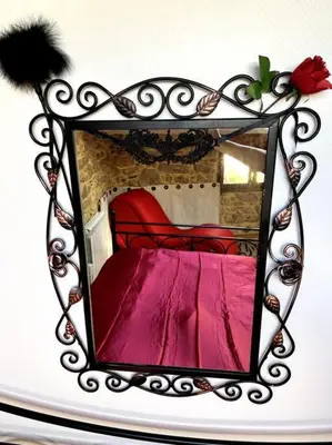 a mirror with a red bed in a room at Love room de Blanche Neige in Assignan
