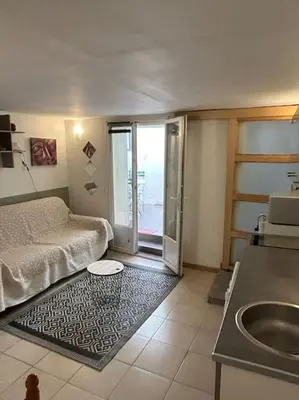 a living room with a bed and a rug at Studio Sanae in Lézignan-Corbières