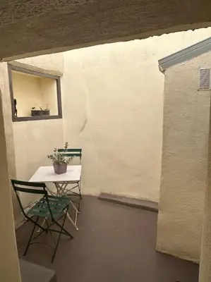a room with a table and a chair and a plant at Studio Sanae in Lézignan-Corbières