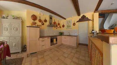 a large kitchen with white cabinets and a large island at Bijou- Charming Traditional Home with Pool in Minervois in Saint-Jean-de-Minervois