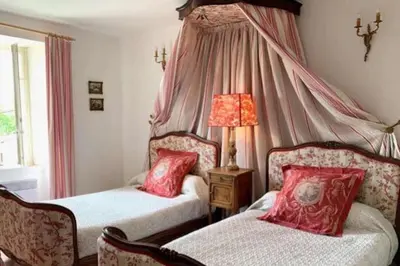 a bedroom with two beds with red pillows at Bijou- Charming Traditional Home with Pool in Minervois in Saint-Jean-de-Minervois