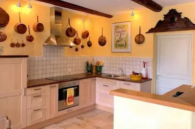 a kitchen with white cabinets and utensils on the wall at Bijou- Charming Traditional Home with Pool in Minervois in Saint-Jean-de-Minervois