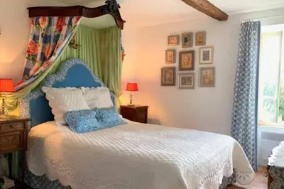 a bedroom with a blue and white bed and a window at Bijou- Charming Traditional Home with Pool in Minervois in Saint-Jean-de-Minervois