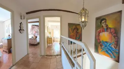 a staircase in a home with paintings on the walls at Bijou- Charming Traditional Home with Pool in Minervois in Saint-Jean-de-Minervois