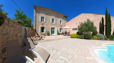 a stone house with a swimming pool in front of it at Bijou- Charming Traditional Home with Pool in Minervois in Saint-Jean-de-Minervois