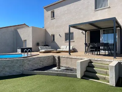 a backyard with a swimming pool and a house at Charmante maison avec petite piscine et jardin in Port-la-Nouvelle