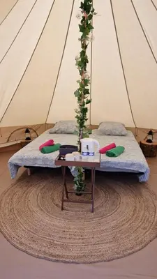 a room with two beds and a table with a tree at Lodge tente les pommiers Glamping Ô rendez-vous en demi-pension in Roquefeuil