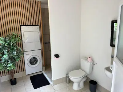 a bathroom with a washing machine and a washer at Lodge tente les pommiers Glamping Ô rendez-vous en demi-pension in Roquefeuil