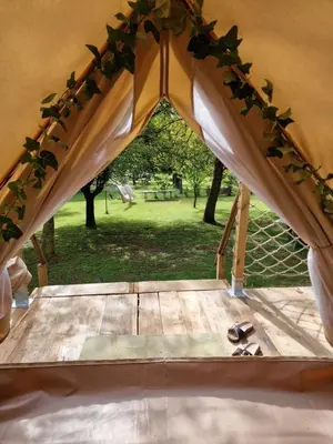 a tent with a wooden table in a park at Lodge tente les pommiers Glamping Ô rendez-vous en demi-pension in Roquefeuil