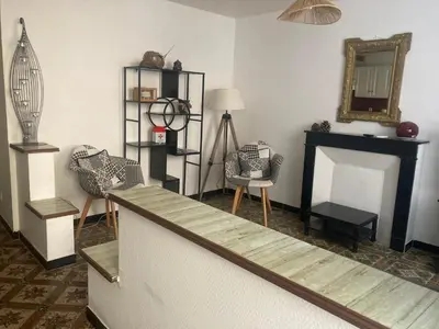 a living room with two chairs and a fireplace at Maison RASSIER, Gîte Vélo in Sainte-Eulalie
