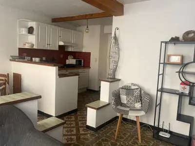 a kitchen with a counter and a chair in a room at Maison RASSIER, Gîte Vélo in Sainte-Eulalie