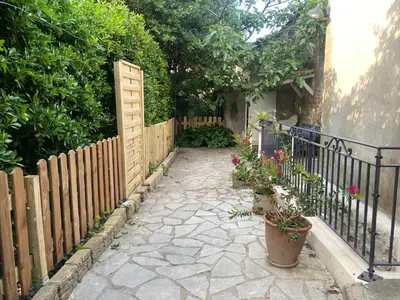 a garden with a fence and potted plants at Maison RASSIER, Gîte Vélo in Sainte-Eulalie