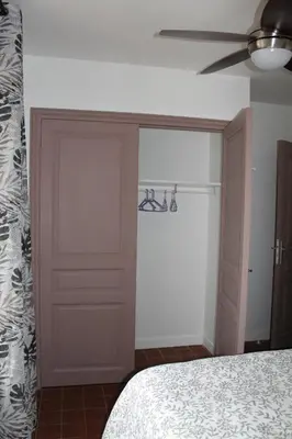 a bedroom with a closet and a ceiling fan at Bel Appartement T2 in Carcassonne