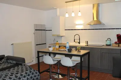 a kitchen with a table and chairs and a sink at Bel Appartement T2 in Carcassonne