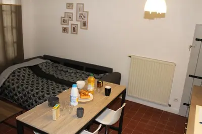 a room with a table with food on it with a bed at Bel Appartement T2 in Carcassonne