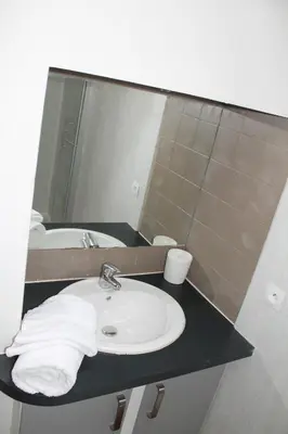 a bathroom with a sink and a mirror at Bel Appartement T2 in Carcassonne