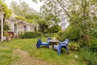 a table and three blue chairs in a yard at Chez Claudie et Jacques in Ventenac-Cabardès