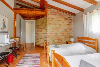 a bedroom with a bed and a brick wall at Chez Claudie et Jacques in Ventenac-Cabardès