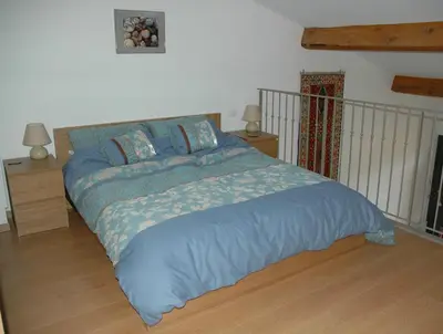 a bed with a blue comforter in a bedroom at Superb villa for 4, private pool in Durban-Corbières