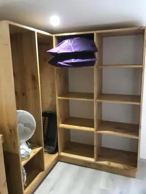 a closet with wooden shelves and a purple pillow at Petite maison in Carcassonne