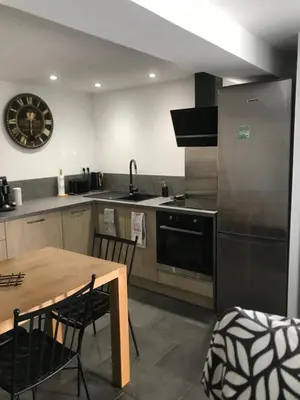 a kitchen with a table and a stove and a refrigerator at Petite maison in Carcassonne