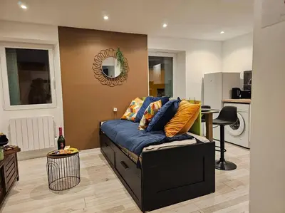 a living room with a couch and a bottle of wine at Cap-vert Evasion *Centre-ville*Cap Occitanie*005 in Limoux