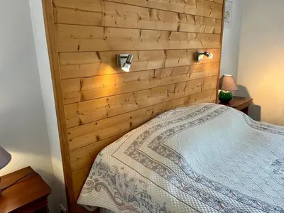 a bedroom with a wooden headboard and a bed at Le gîte du Clos d'André in Castelnaudary
