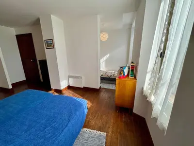 a bedroom with a blue bed and a wooden floor at Le gîte du Clos d'André in Castelnaudary