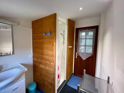 a bathroom with a shower and a wooden door at Le gîte du Clos d'André in Castelnaudary