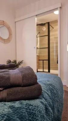 a pile of towels sitting on top of a bed at T2 quartier Mermoz, 2 places de parking privées in Pamiers