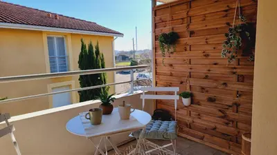 a balcony with a table and chairs on a building at T2 quartier Mermoz, 2 places de parking privées in Pamiers