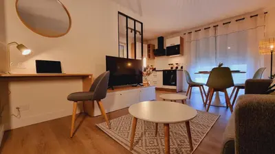 a living room with a television and a table and chairs at T2 quartier Mermoz, 2 places de parking privées in Pamiers