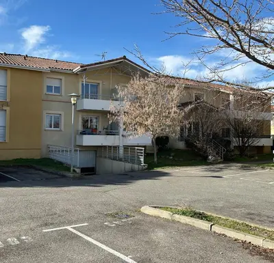 a parking lot in front of a building at T2 quartier Mermoz, 2 places de parking privées in Pamiers