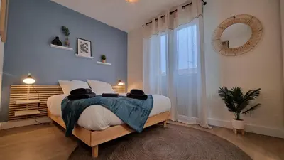 a bedroom with a bed and a large window at T2 quartier Mermoz, 2 places de parking privées in Pamiers