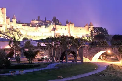 a view of a castle at night with a bridge at Appartement avec terrasse centre de la Bastide in Carcassonne